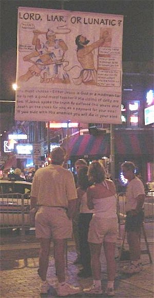 Ken witnessing with a banner on Beale Street